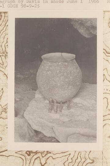 Olla and prehistoric corncobs at mouth of Olla Vieja Cave where they were found in 1966, May 31, by Donald Davis. Photograph taken in shade