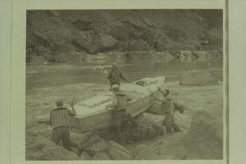 Portage of Caltech boat at Vulcan Rapid. Frank Dodge is on the port side of the boat. Owen Clark, Merrill Spencer, and Ian Campbell are inshore
