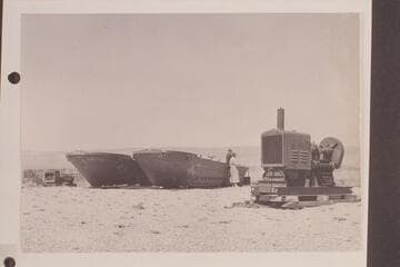 Barges at the rim prepared to be lowered to the Marble Canyon dam site at 39 where they were used as a platform for the drilling. Margaret Marston talks with one of the crew