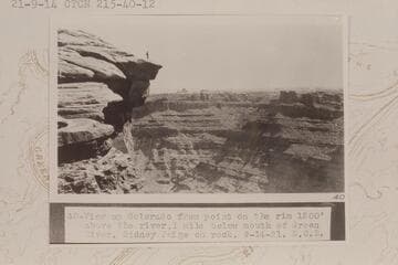 Up at head of Cataract Canyon from Mile 215 1/2. View up Colorado from point on the rim 1200' above the river, one mile below mouth of Green River. Sidney Paige on rock