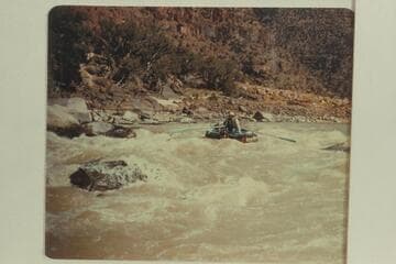 10-man inflated boat dropping into the head of Disaster Falls. Bus Hatch is at the oars and Edward Tuttle rides as passenger